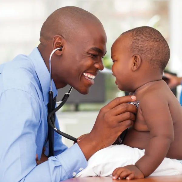 Doctor holding stethoscope to baby's chest