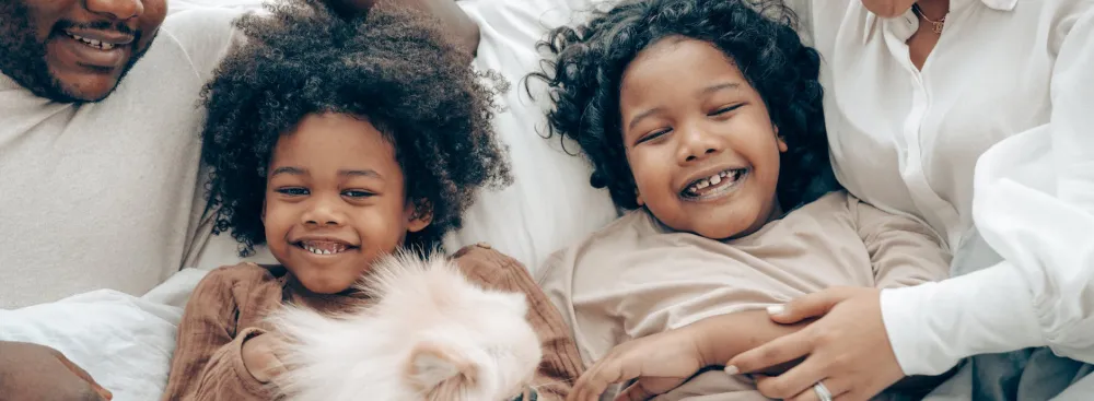 Black parents holding two small children