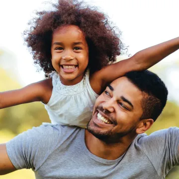 Dad with daughter on back smiling