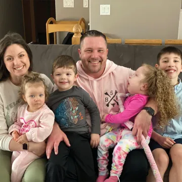 Photo of happy family inside their house with parents and four children.