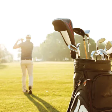 Man golfing with golf bag behind him