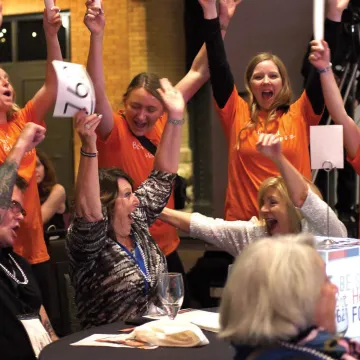 Volunteers celebrating with attendees at a non-profit gala