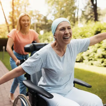 Woman outside happy being pushed in wheelchair